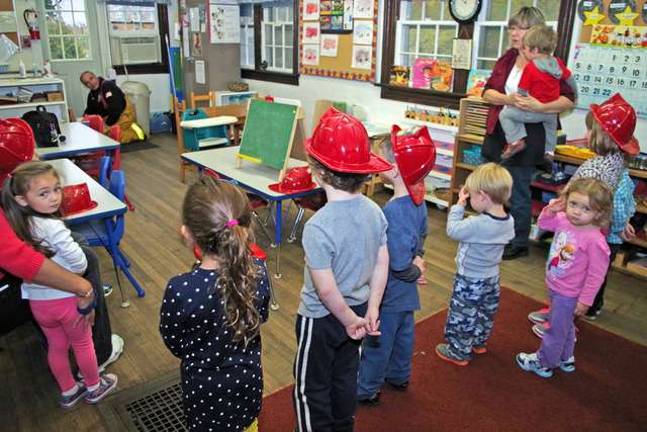 Never too young to learn about fire safety Bob Winter explains how to crawl through a potentially smoke filled room to safely feel whether there may be heat and fire on the other side of a closed door.