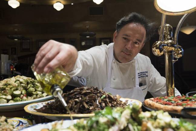 Veteran Chef Brings Classical Training–and Grandma’s Meatball Recipe–to Iconic Manhattan Restaurants Chef Brando de Oliveira applies some olive oil at Bond 45 restaurant.