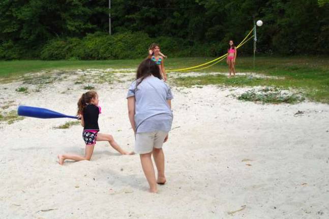 These girls played wiffle ball with a considerably oversized bat.