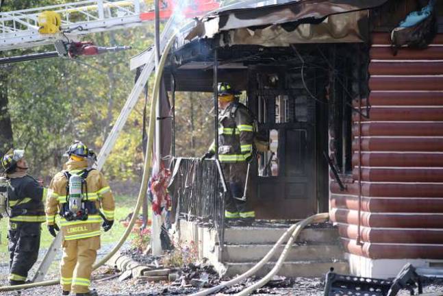Firefighters work to extinguish a fire at the Log Cabin Inn in Wantage on Sunday.