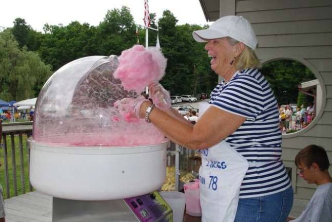 Highland Lakes resident and Queen of the Highland Hatters chapter of the Red Hat Society volunteer Pat Wootton ended up laughing at the rather odd shapes of the cotton candy that she way trying to create for the kids.