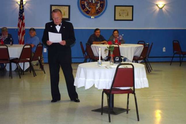 Fred Spages of the Sussex Elks Lodge No. 2288 explains the meaning of the empty table that honors those military personnel who remain prisoners of war.