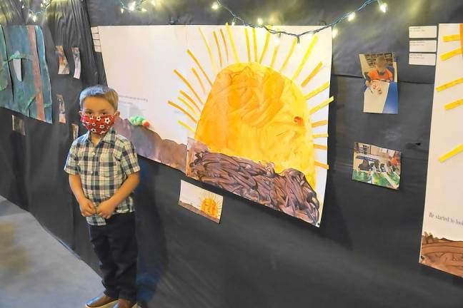 Jeremy stands by the sun he helped paint (Photo by Vera Olinski)