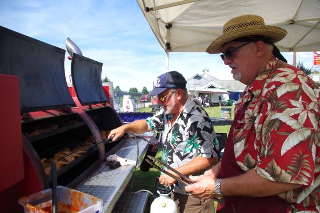 PHOTOS BY CHRIS WYMAN Pit Master Jay Altamore and Chef Dan Lemire of Chumleys BBQ and Catering of Florida, N.Y. are shown cooking up some chicken.