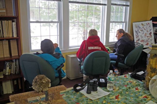 Wallkill Refuge hosts Great Backyard Bird Count High school students are shown looking out a series of windows at a suspended birdfeeder.