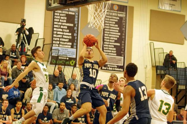 Pope John's Aaron Clarke takes the ball towards the hoop in the the fourth period.