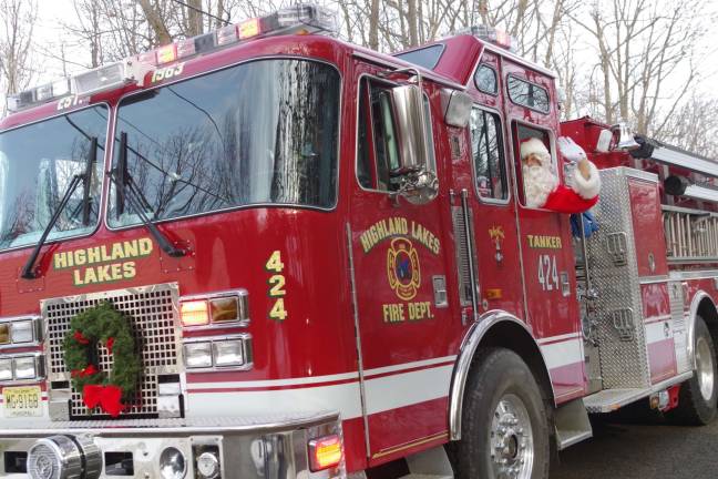 santa visit PHOTOS BY CHRIS WYMAN A Highland Lakes Fire Department ladder truck brought Santa Claus down the center of Barry Drive South in the Barry Lakes section of Vernon on Saturday, Dec. 21. The Fire Dept. took Santa Claus on a tour of the various neighborhoods on Wawayanda Mountain. With Christmas music playing and sirens honking and screaming, a ladder truck with its flashing red and amber emergency lights made its way up and down the side streets of the Barry Lakes, Highland Lakes, and Lake Wanda sections of Vernon. During this annual tradition, the truck gave the residents plenty of noisy warning so that their children can come out to meet and wave to the jolly old elf.