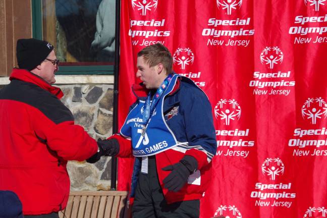 Vernon Mountaineers perform at Special Olympics Vernon Mountaineers skier Lawrence Bono of Wantage offers a firm handshake after he received his medal. Bono was first in the novice slalom and second in the novice Super G.