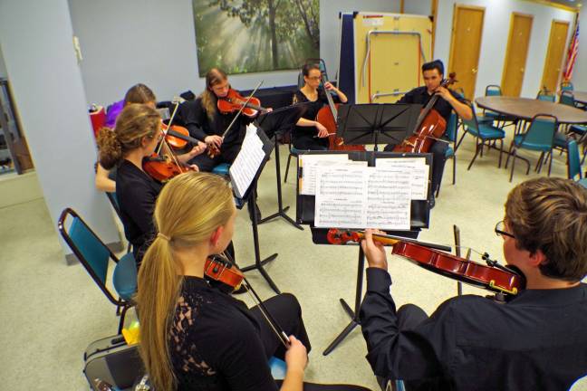 The Vernon Township High School Chamber Orchestra, a septet of stringed instrument musicians perform at the photography exhibition.