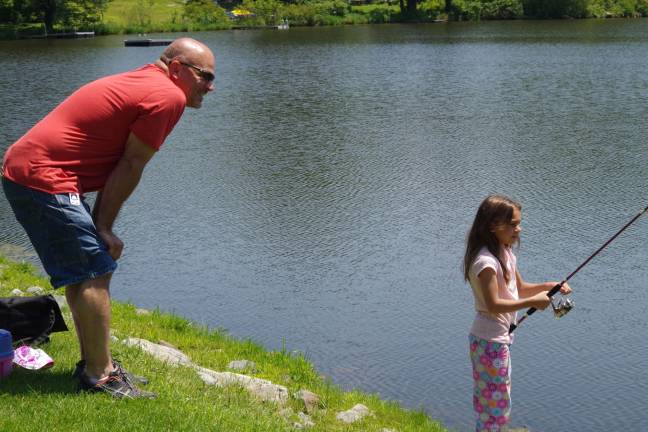 Gabriella Cefaloni, 7, is shown fishing as her father Joe keeps a watchful eye.