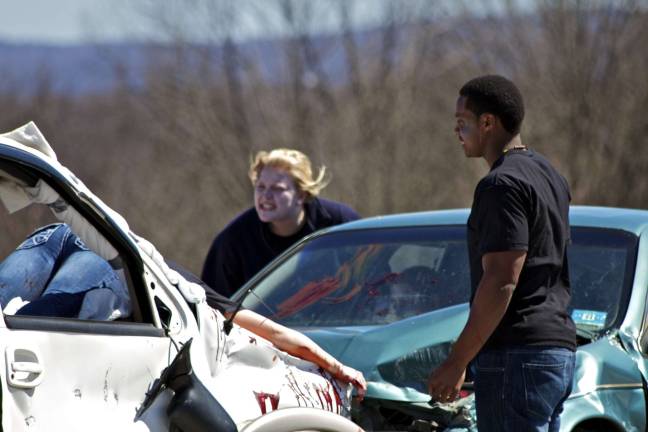 Staged fatal crash Sean Anglin, who plays a passenger with minor injuries, looks at the carnage. Photos by Joe Hicks
