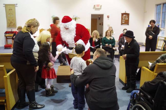 Choral Society performs at St. Thomas church Santa Claus who asked for the children to come to the front of the church and join him in song in return for treats.
