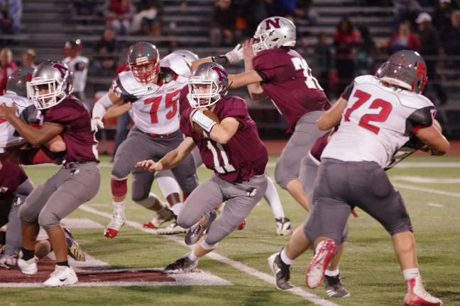 Newton quarterback Jack Young runs with the ball as his teammates protect him from High Point defenders in the first half. Young passed for 339 yards resulting in 4 touchdowns.