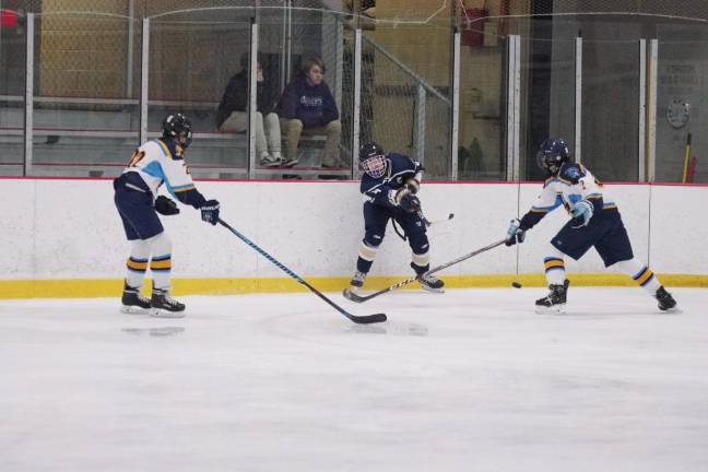 Roxbury defeats Sparta-Jefferson The puck sails through the air between two Sparta-Jefferson United players after being hit by a Roxbury Gael in the first period.