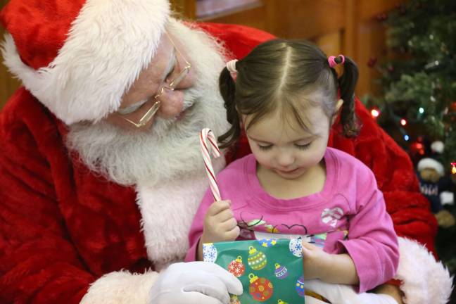 American Legion hosts lunch with Santa Santa gives Aubrie Strick of Wantage a goodie bag while listening to her wish list.