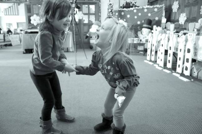 Church holds Christmas craft event Sierra O'Rourke and Isabella Velasco of Hamburg have fun dancing it up for Santa at the Church of the Good Sheperd Christmas crafts.