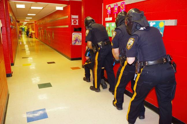 Being prepared Photo by Chris Wyman Four Vernon police officers are shown during a drill about to enter a classroom in search of three gunmen.