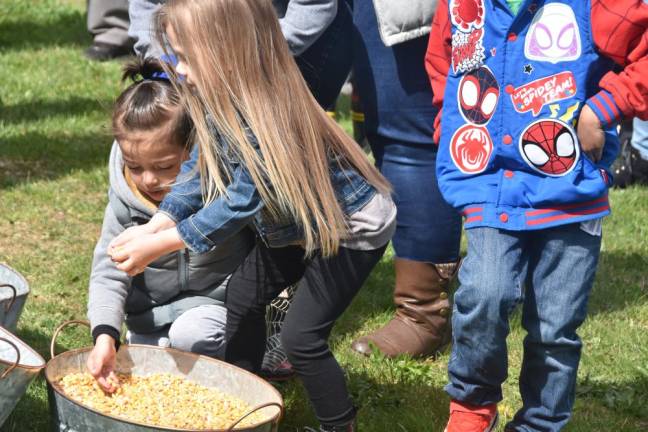 Panayiotis Portella and a classmate take a turn mixing chicken feed from corn, soybeans and oats.