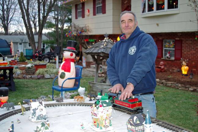Photos by Chris Wyman Bob Winter is shown with a train that is new to his annual display. This is one of two lighted miniature train sets that are part of his annual Christmas display.