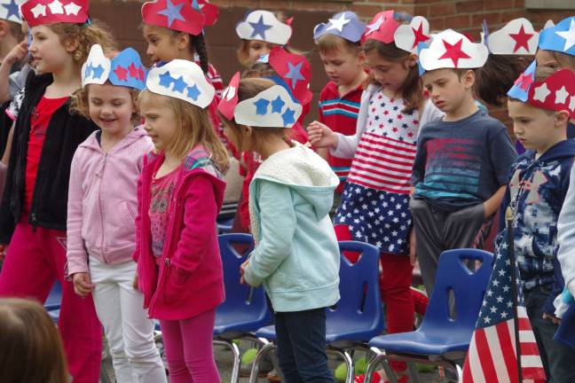 Walnut Ridge students offer patriotic songs for veterans and family members Young students singing "This Land Is Your Land."