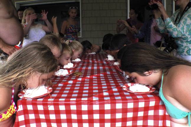 At left, Katie Molini, 10, and Isabella Ferreri, 11, at right, bob for M&amp;Ms covered with whipped cream.