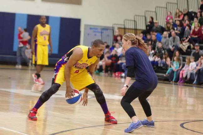 Harlem Wizard Devon &quot;Livewire&quot; Curry does some fancy dribbling while shadowed by an opponent.