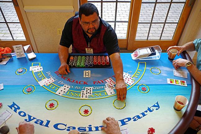 A dealer from Royal Casino Party picks up a losing players bet during the Veteran&#xfe;&#xc4;&#xf4;s Cemetery Casino Night Fundraiser held at St. Francis de Sales Church on Saturday evening.