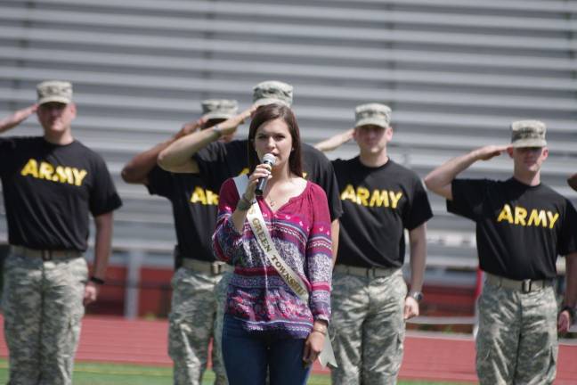 Miss Green 2014 Michele Ann Lawrey sings the National Anthem with members of the U.S. Army in the background.