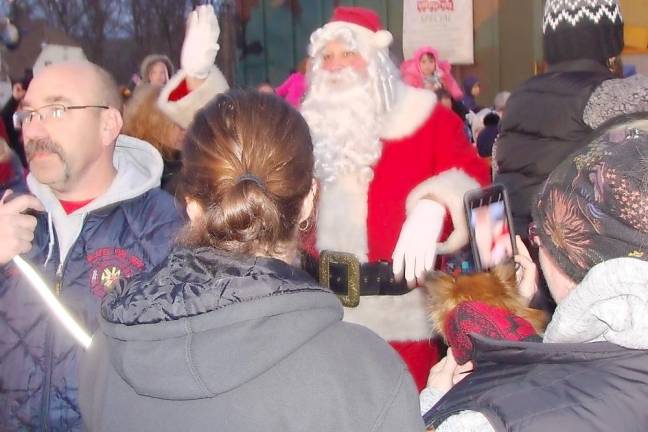 Santa Claus mingles with the crowd as he emerges from the train.