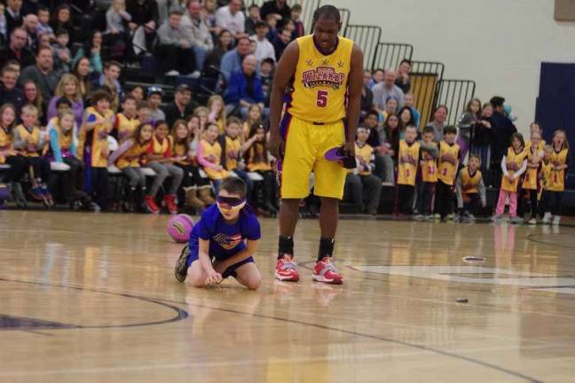 Silliness ensues as a young fan participates in one of the Harlem Wizards antics.