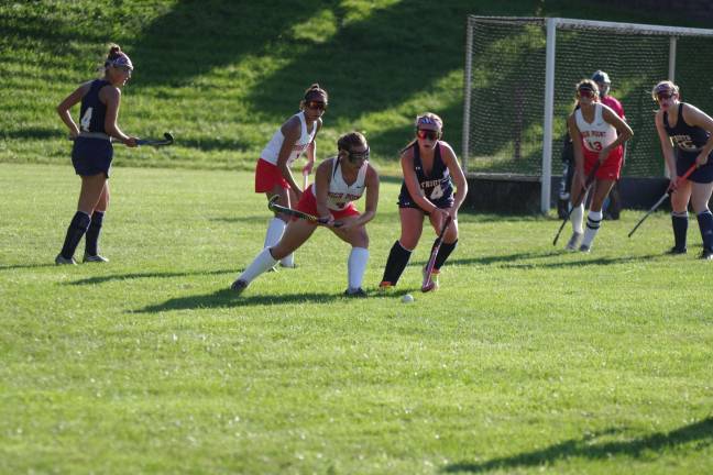 High Point's Michaela Thiessen begins to swing her stick at the ball as Lenape Valley's Jayna Rode uses her stick to reach towards it.