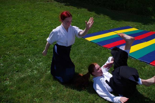 Children gather to punt, pass and kick Aikido practitioners, of Sparta Aikido, Jess Taylor and Daniella Weber during a demonstration at the event.