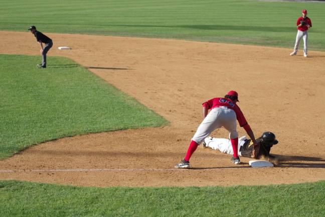 Jackals first baseman Art Charles is too late with the tag on Miners runner Jay Austin in the fourth inning.