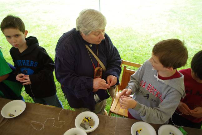 Colonial Day brings lessons and fun Karen Ferlauto of the Lake Wanda section of Vernon helped the children make beaded necklaces. Beads were a common commodity used to trade with Native Americans.