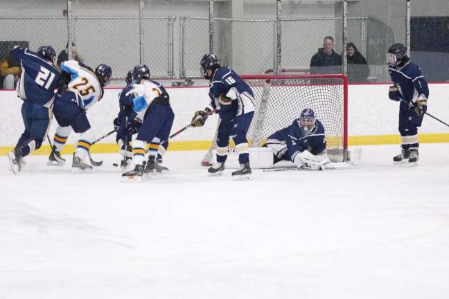 Roxbury defeats Sparta-Jefferson Roxbury and Sparta-Jefferson United hockey players battle for control of the puck near the goal post in the first period.