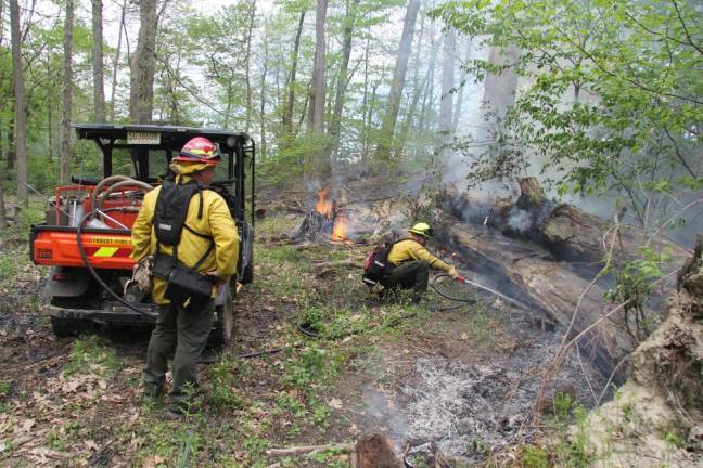 Lighting a fire under science students A firefighter uses water to control the blaze. (Photo courtesy of High Point Regional High School)