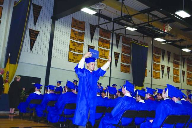 Vernon Township High School graduate Carlos Rosa proudly points to his diploma.