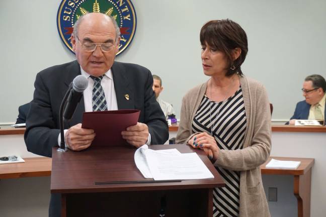 Freeholder Richard Vohden reads the proclamation designating April as Sexual Assault Awareness Month. Gwen Federico of DASI on right.