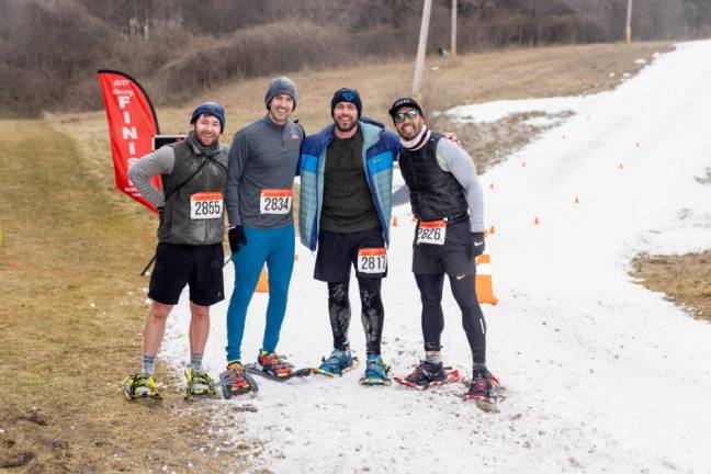 The top four finishers pose at the finish line. From left are Matthew Moran, Stephen Heuzey, Allen Collins, and Kristian Elvina. Moran won the race with a time of 22:01. Collins, 39, of Sussex placed third with a time of 22:20.