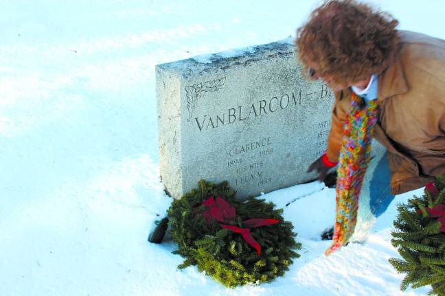 DAR member Allyn Perry lays a wreath at a grave as partnered with the group's affiliation with Wreaths Across America.
