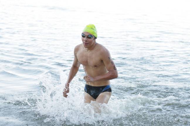 Seventeen-year-old Chris Rudel, of Sparta, was the first to emerge from the water in the first phase of the triathlon.