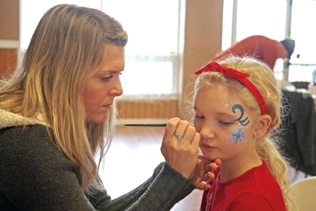 Barry Lakes hosts Breakfast with Santa Kim Olsen Scotto of Warwick-based Let's Face It paints the face of Katie Molini, 8, of Barry Lakes.