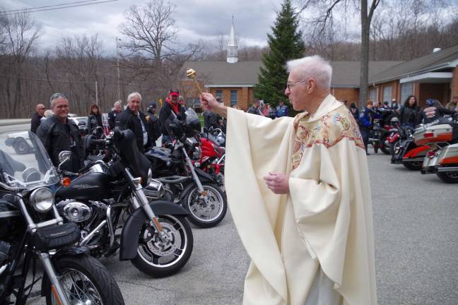 Monsignor Robert Carroll sprinkles holy water on the dozens of motorcycles and their riders.
