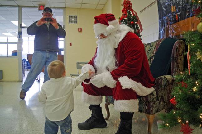 VTHS hosts Breakfast with Santa Jase Van Den Broek, 18 months, of Wantage warmed up to Santa Claus and the two passed candy canes and jingle bells back and forth. Vernon resident Tom Smaldone of Vernon arranged for Santaís visit to the high school.