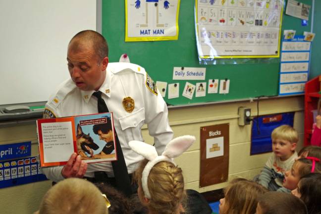 Photo by Chris Wyman Vernon Police Department Lt. Daniel B. Young uses a book about police and police dogs to teach the children.