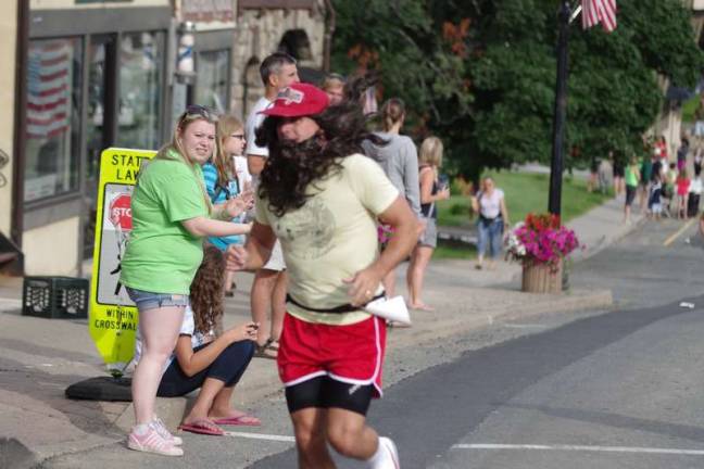 Long hair to go along with long strides Mike Abrams of Sparta, NJ on the move while dressed as Forrest Gump.