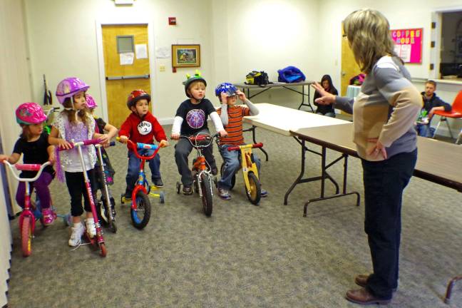 Footprints Montessori School director Mrs. Bjorg Boschen explains the safety rules to the second group of racers. No helmet, no race.