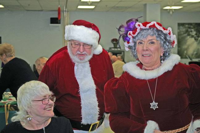 Vernon seniors celebrate holidays Mr. And Mrs. Santa Claus who were portrayed by Tony and Barbara Laufnick are shown giving a billion dollar chocolate bar to Mrs. Bunny Music.