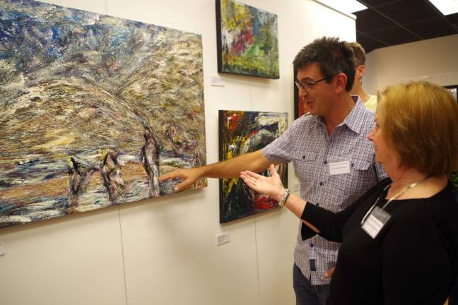 Abstract expressionist artist/gallery director John Maione Jr. describes the core basis of his painting &#x201c;Memories from Playa Bianca&#x201d; to fellow artist Patricia Whittle of Green Township.