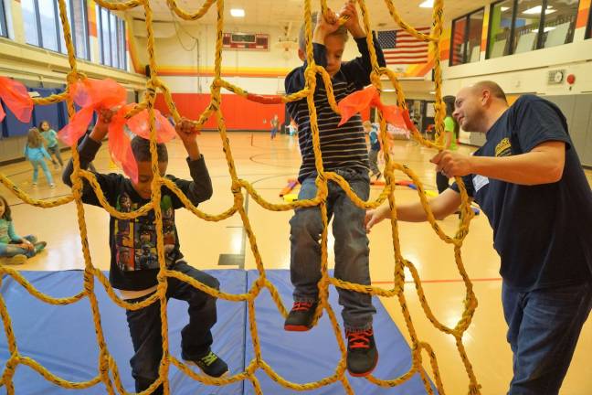 Dedicated Dad Patrick Curreri, on right, helps students climb the rope net.